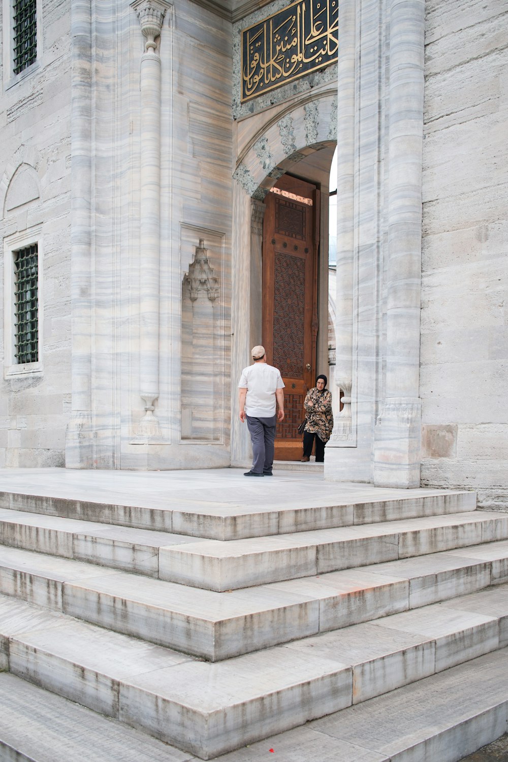 a man and a woman are standing on the steps of a building