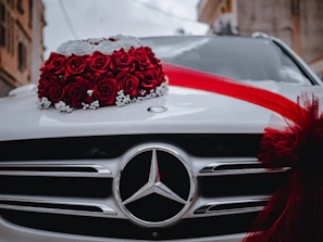 A stylish car decoration with fresh flowers in red and white, captured in natural daylight