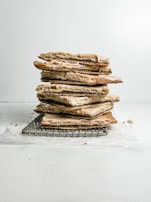 A close-up of flaky, golden-brown savory pastries cooling on a wire rack.