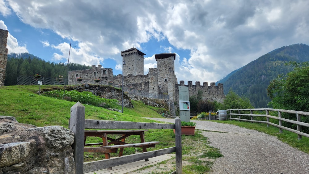 a stone castle sitting on top of a lush green hillside