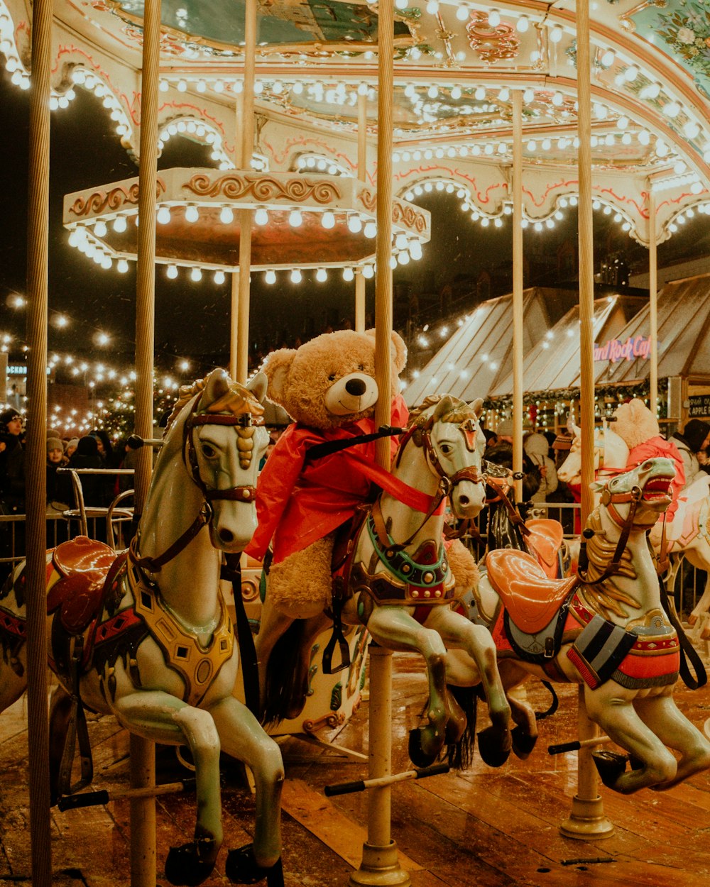 a group of teddy bears riding on top of a carousel