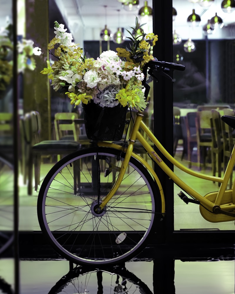Gelbes Fahrrad mit Blumen im Korb