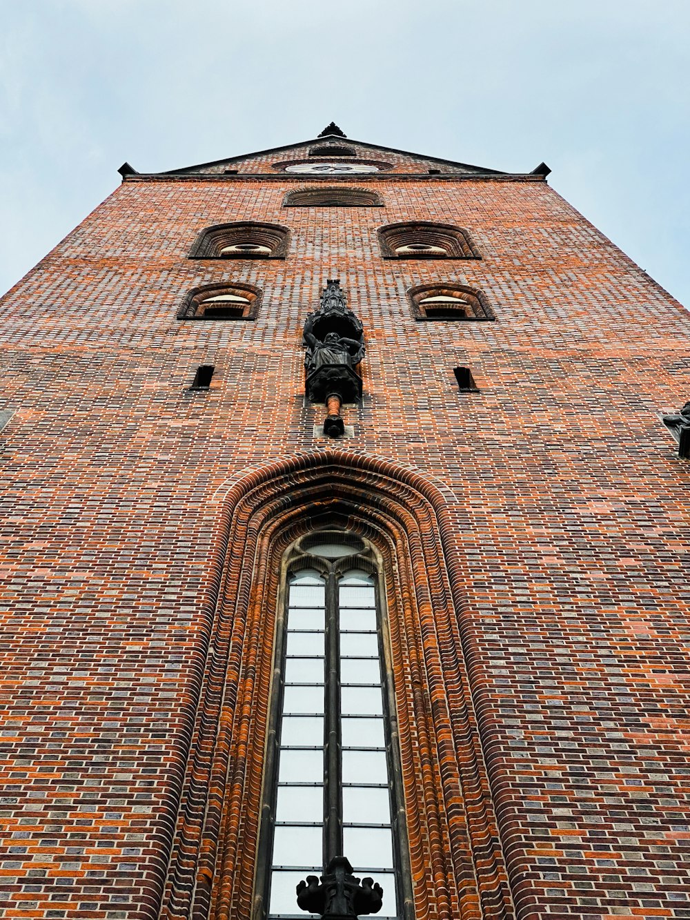 a very tall brick building with a clock on it's side