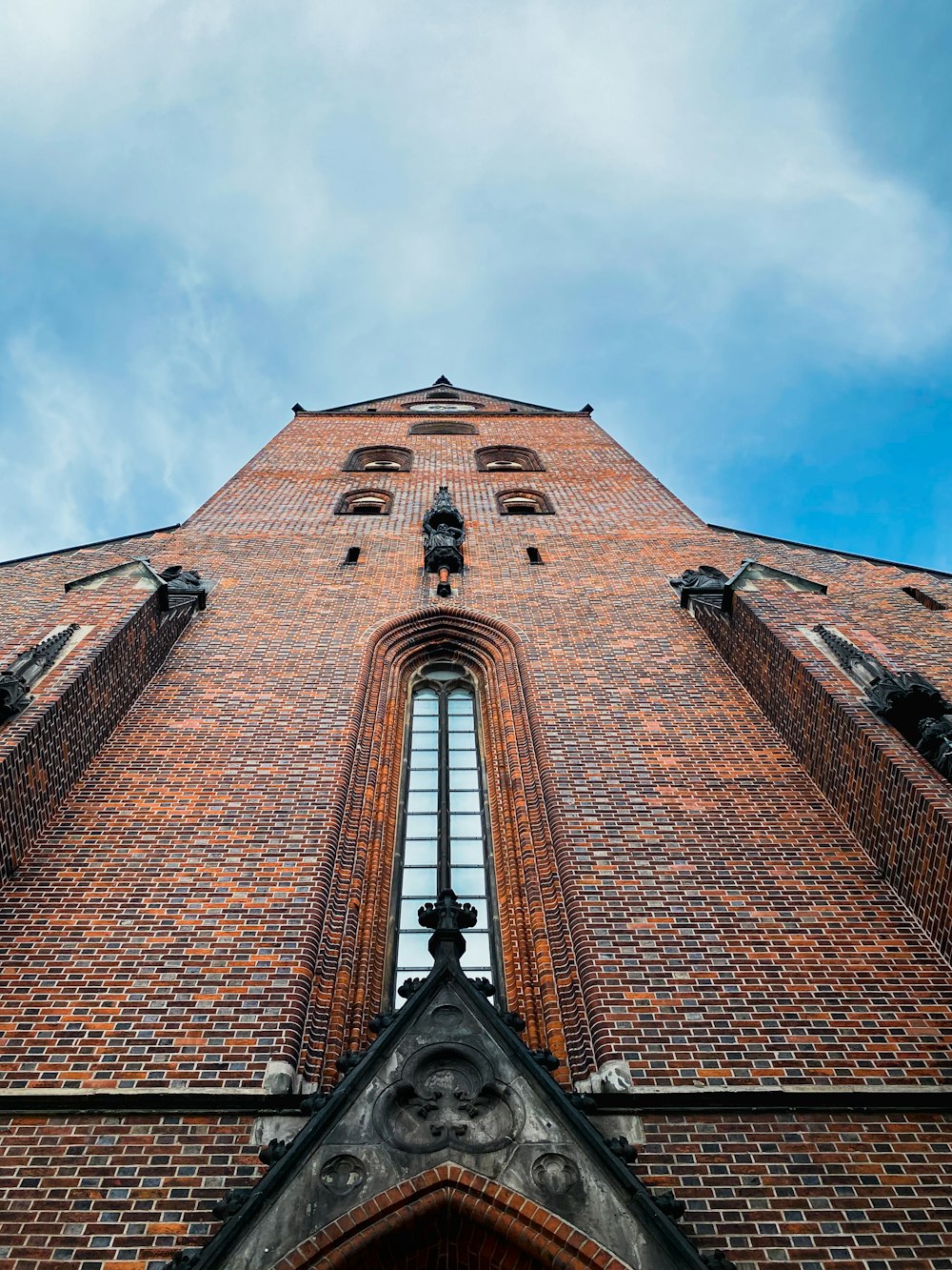 a very tall brick building with a clock on it's side