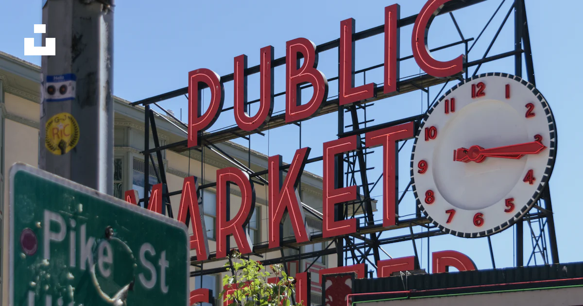 A street sign with a clock on top of it photo – Free Pike place market ...