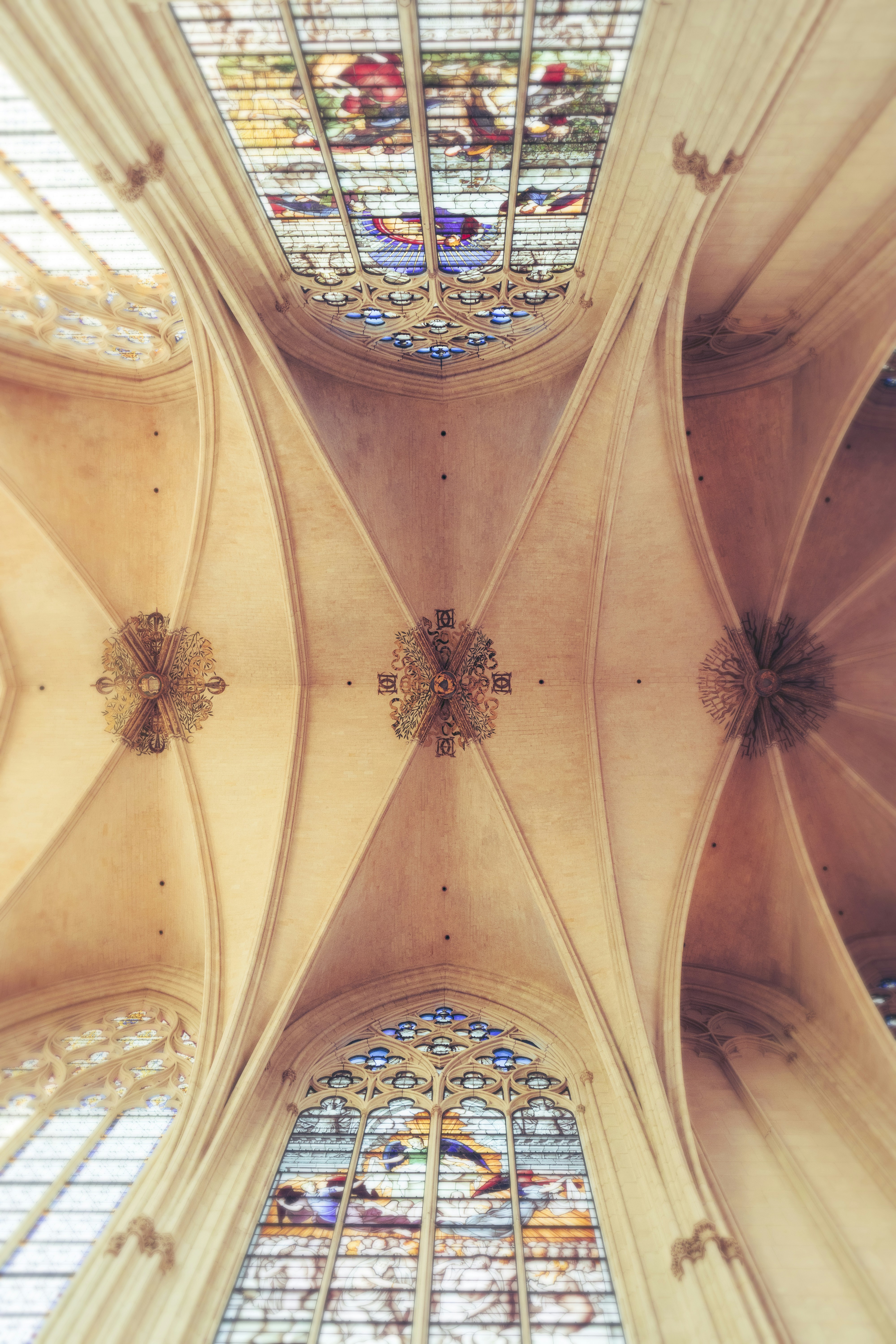the ceiling of a cathedral with stained glass windows