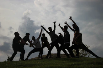 a group of people standing on top of a lush green field