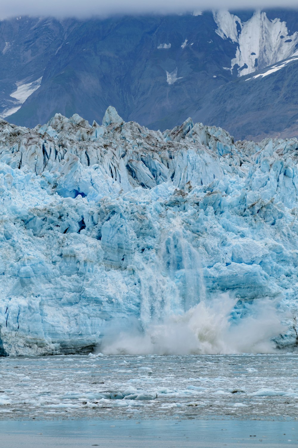 Un gran glaciar con una montaña al fondo