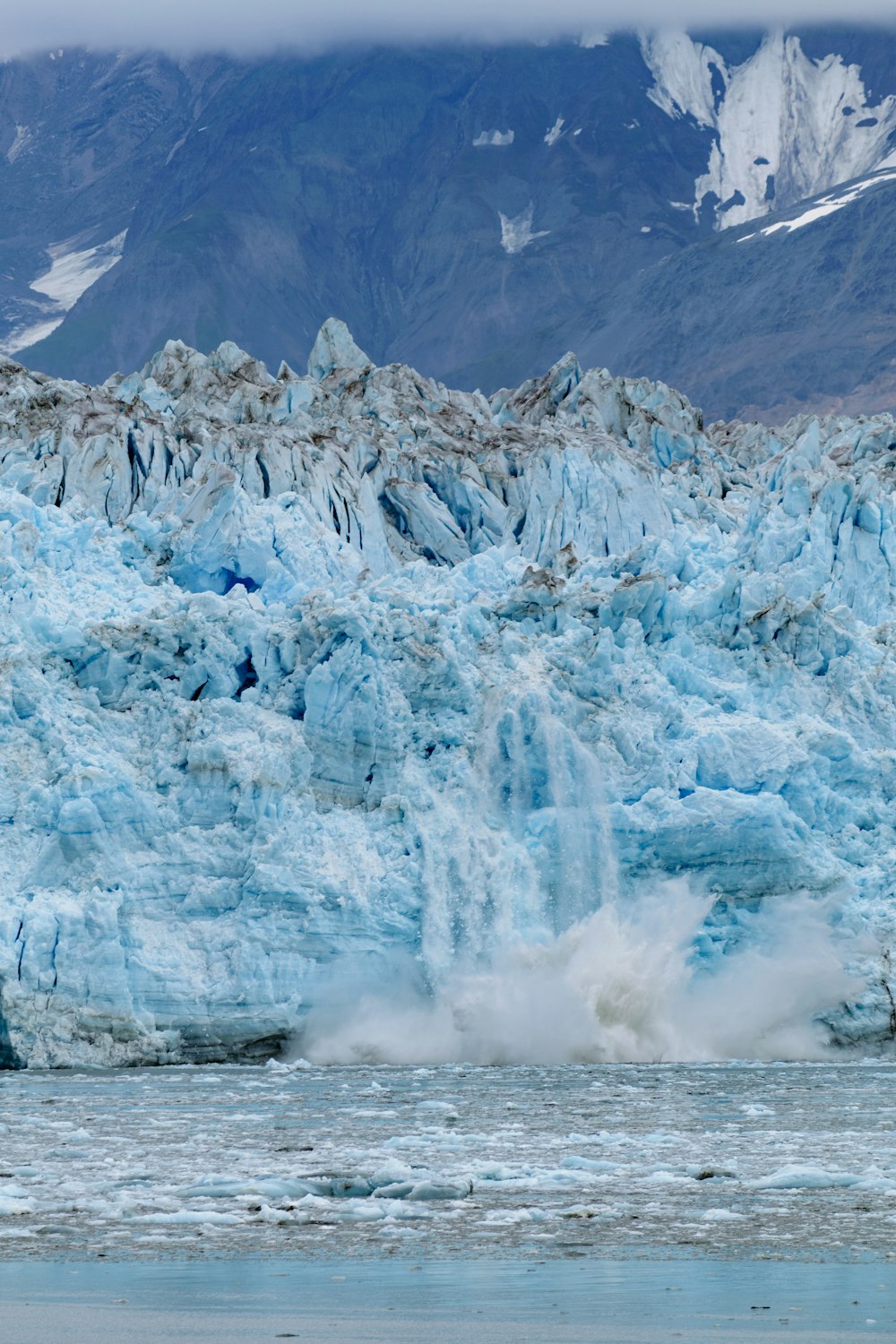 a large glacier with a mountain in the background