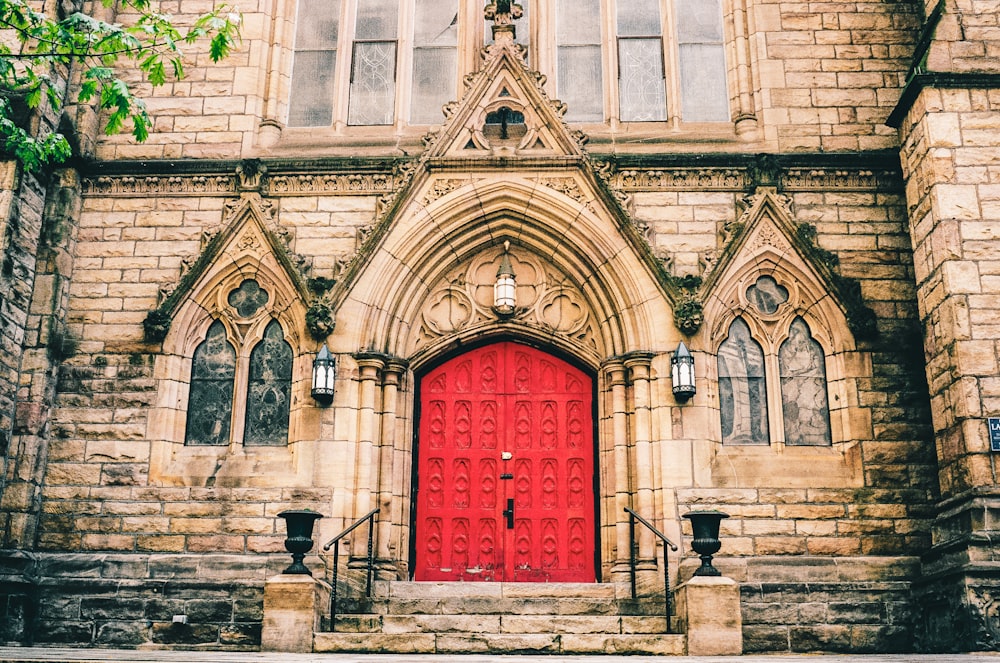a red door in front of a stone church