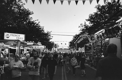 A bustling street fair with food stalls and families having fun.