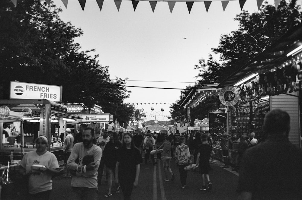 a black and white photo of people walking down a street