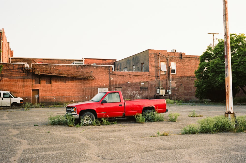 a red pick up truck parked in a parking lot
