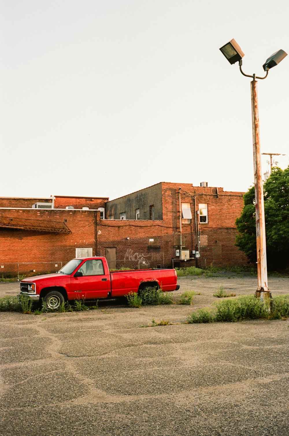 a red truck parked in a parking lot next to a street light