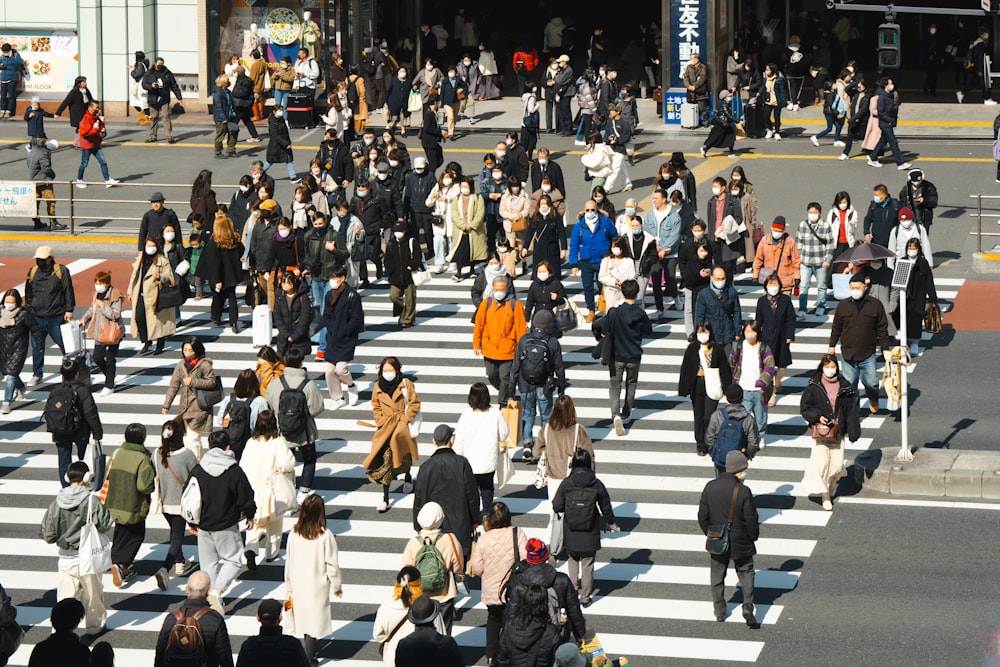 a large group of people walking across a cross walk