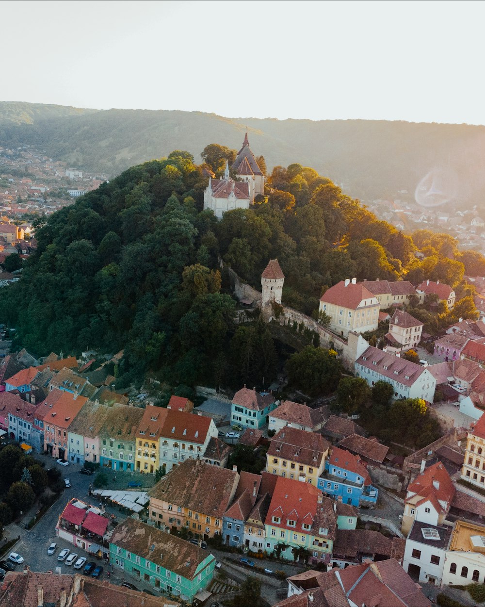 an aerial view of a city with a hill in the background