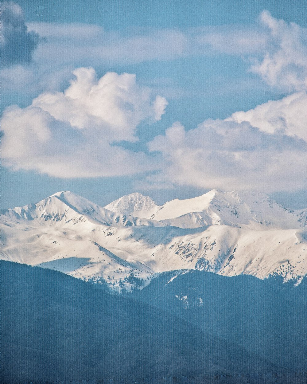 a mountain range with snow covered mountains in the background