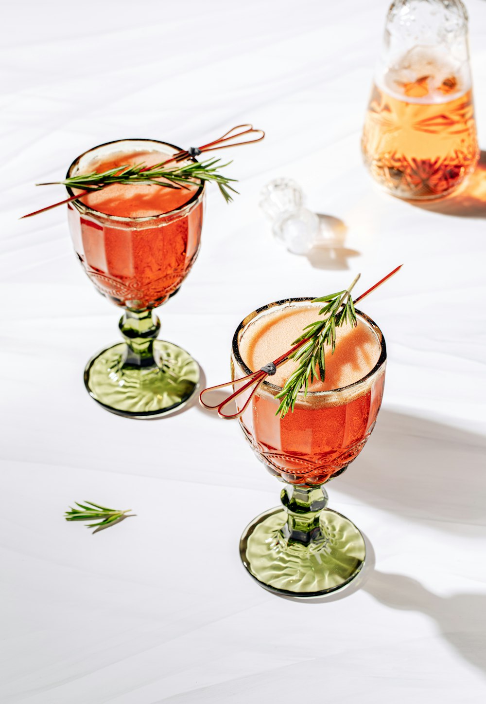 a couple of glasses filled with drinks on top of a table