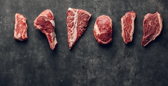a group of raw meats laid out on a table