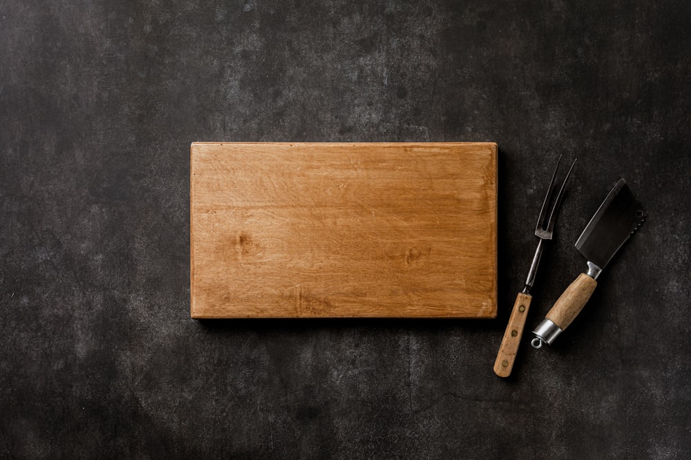 a cutting board with a knife and fork on it