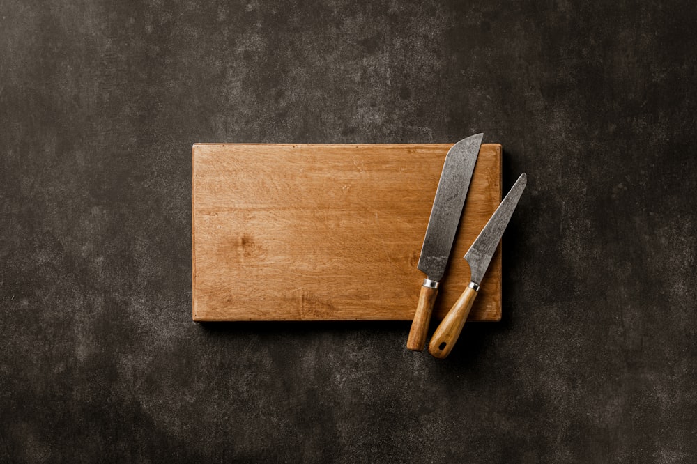 a cutting board with two knives on it