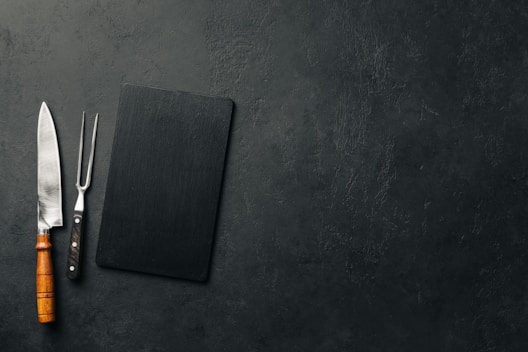A luxurious kitchen knife displayed on a wooden cutting board.