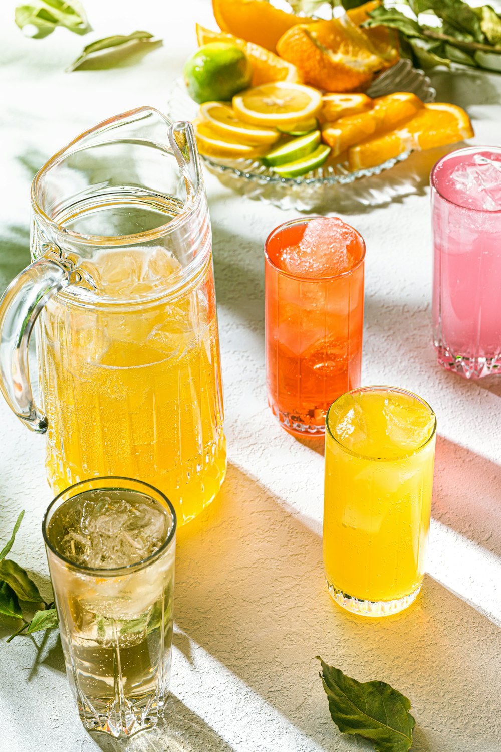 a table topped with glasses and pitchers filled with drinks