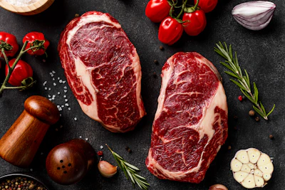 a couple of steaks sitting on top of a table