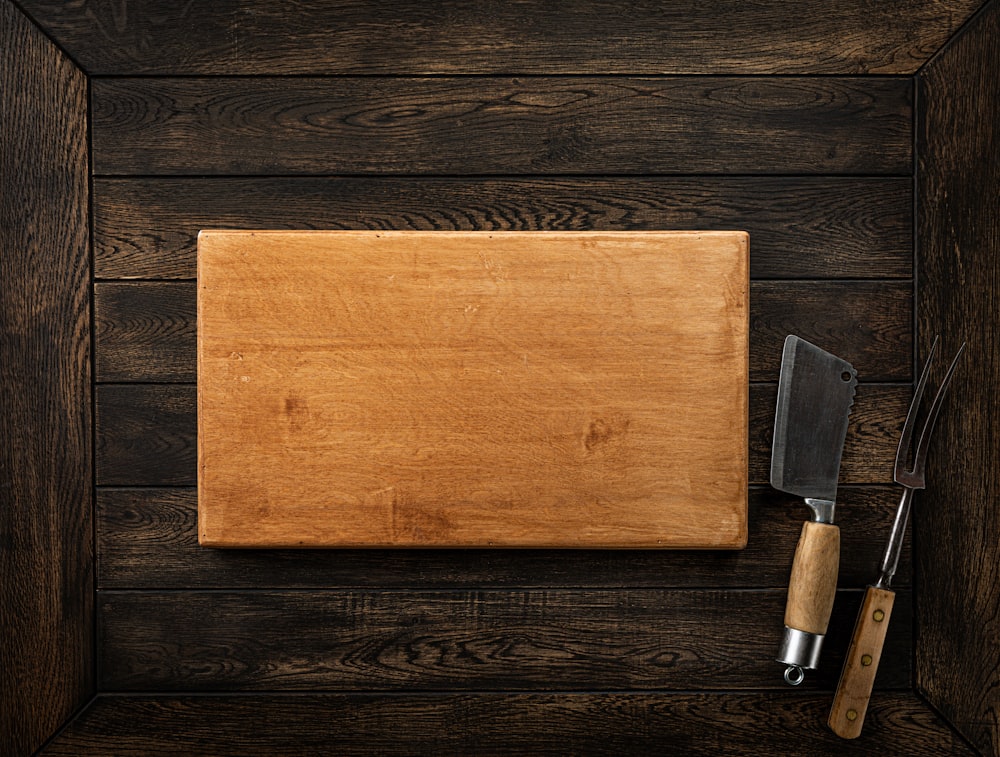 a wooden cutting board with a knife on top of it