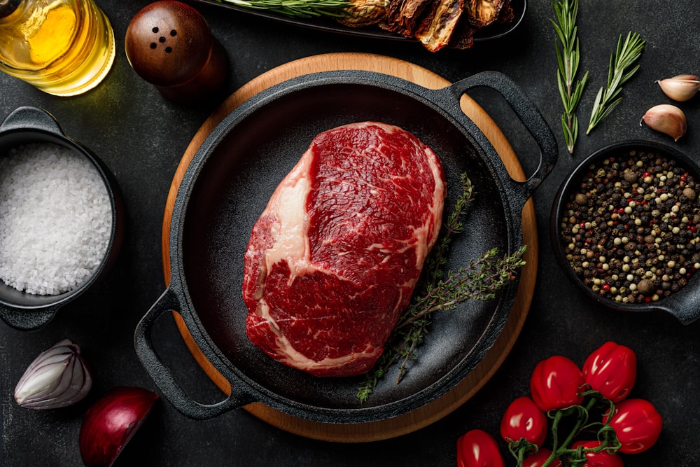 a steak in a skillet surrounded by other ingredients