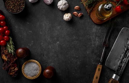 Close-up of a rustic Italian kitchen counter with fresh basil, ripe tomatoes, garlic, and a rolling pin ready for pasta making.