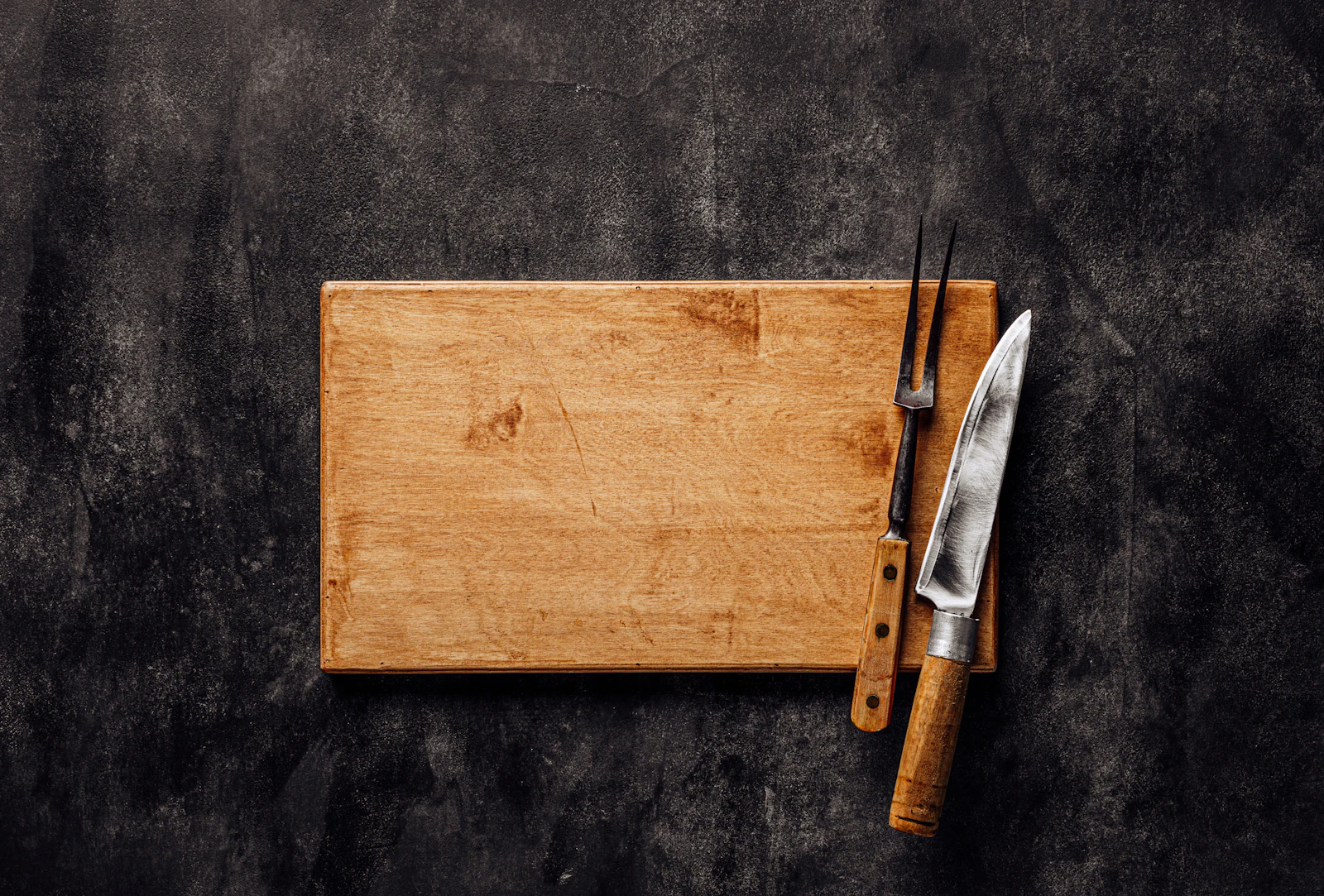 A wooden cutting board with a knife