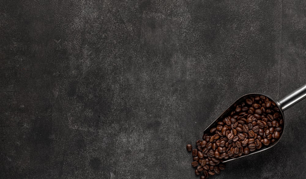 a scoop of coffee beans on a dark background