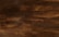 Dark wooden planks arranged horizontally with a textured surface, displaying a rich brown tone with subtle variations and natural grain patterns.