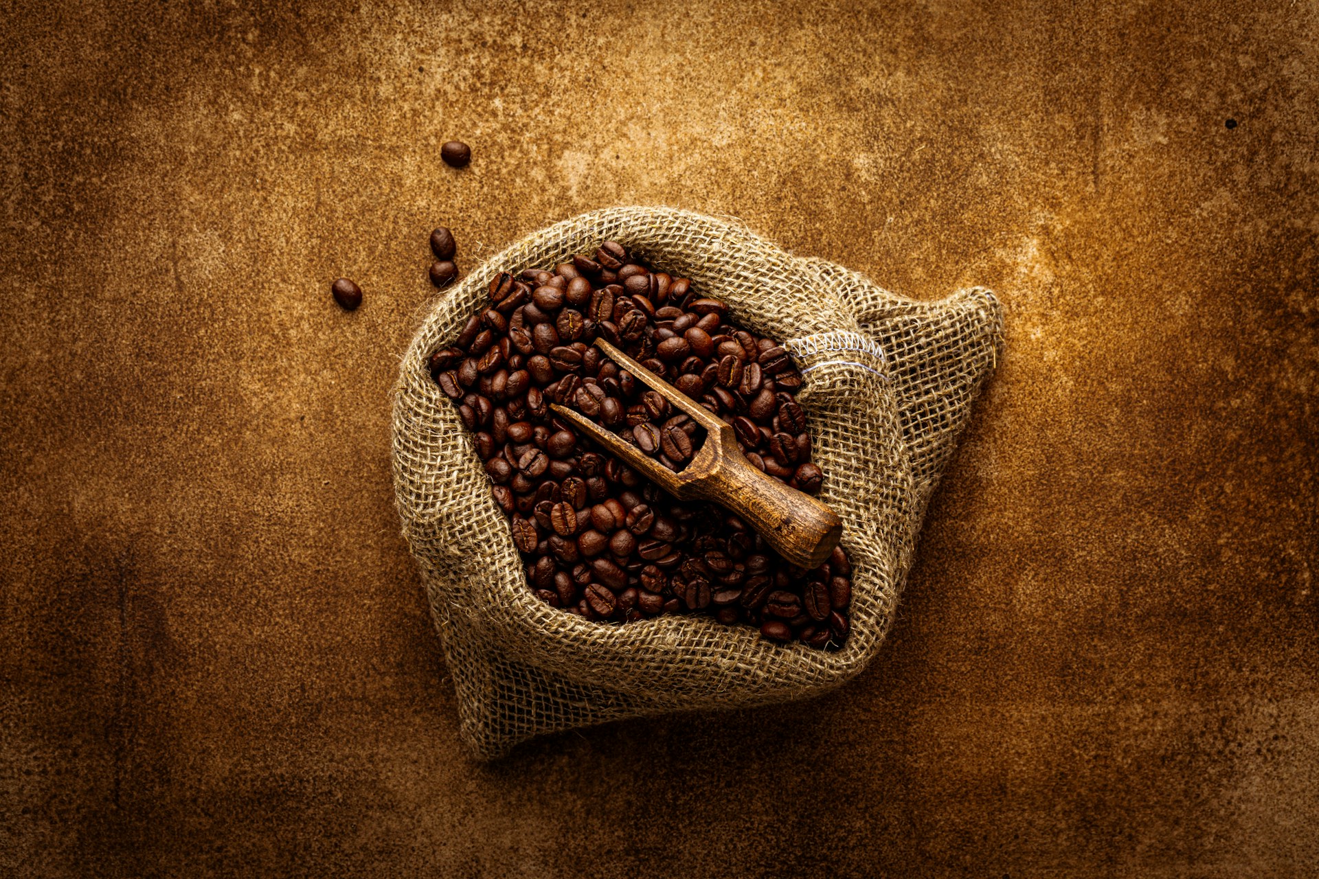 Close-up of a 200-gram pouch of Koboi Coffee resting on a rustic wooden table with coffee beans scattered around.