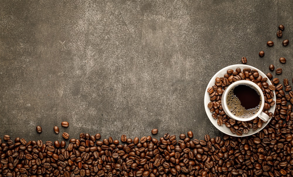 a cup of coffee surrounded by coffee beans