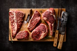 a cutting board with steaks and a knife on it