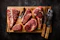 a cutting board with steaks and a knife on it