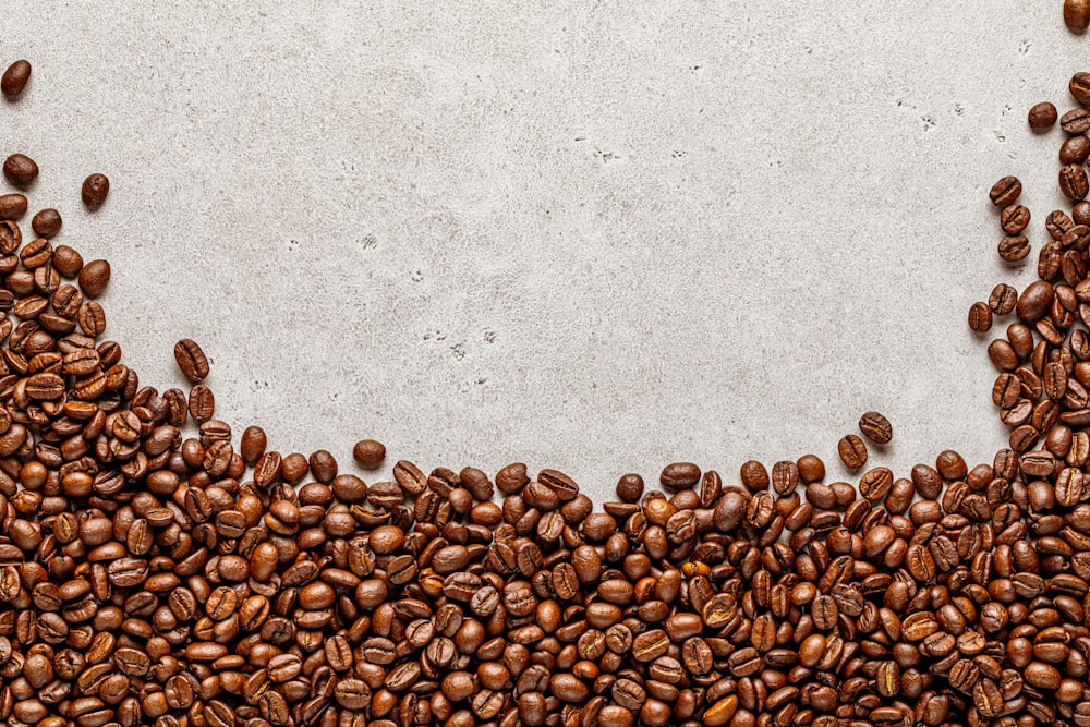 a group of coffee beans on a concrete surface