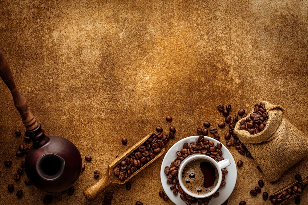 a cup of coffee next to a bag of coffee beans