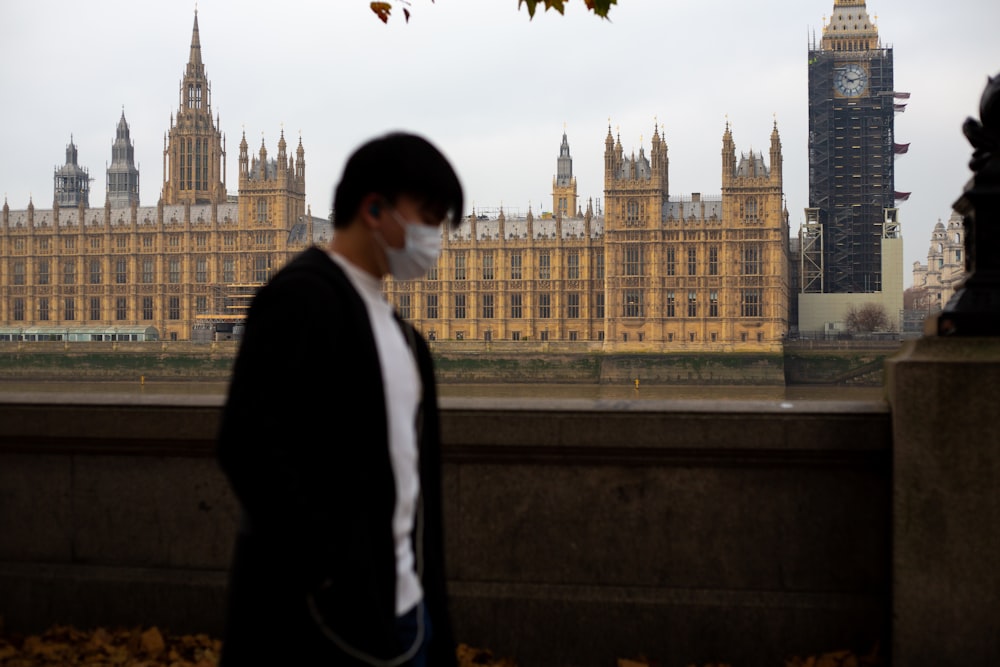 a man wearing a face mask in front of big ben