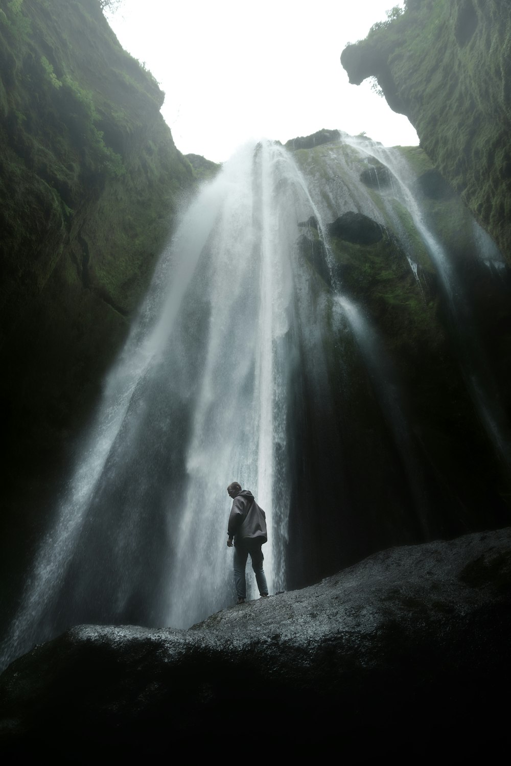 a person standing in front of a waterfall