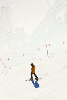 a man riding a snowboard down a snow covered slope