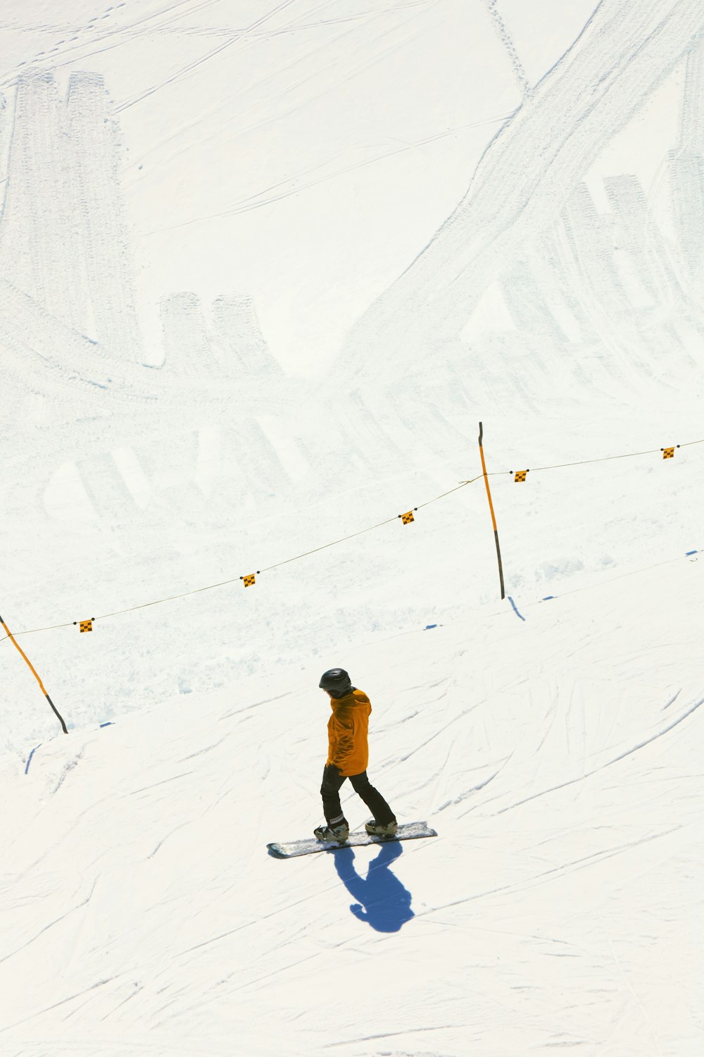 a man riding a snowboard down a snow covered slope