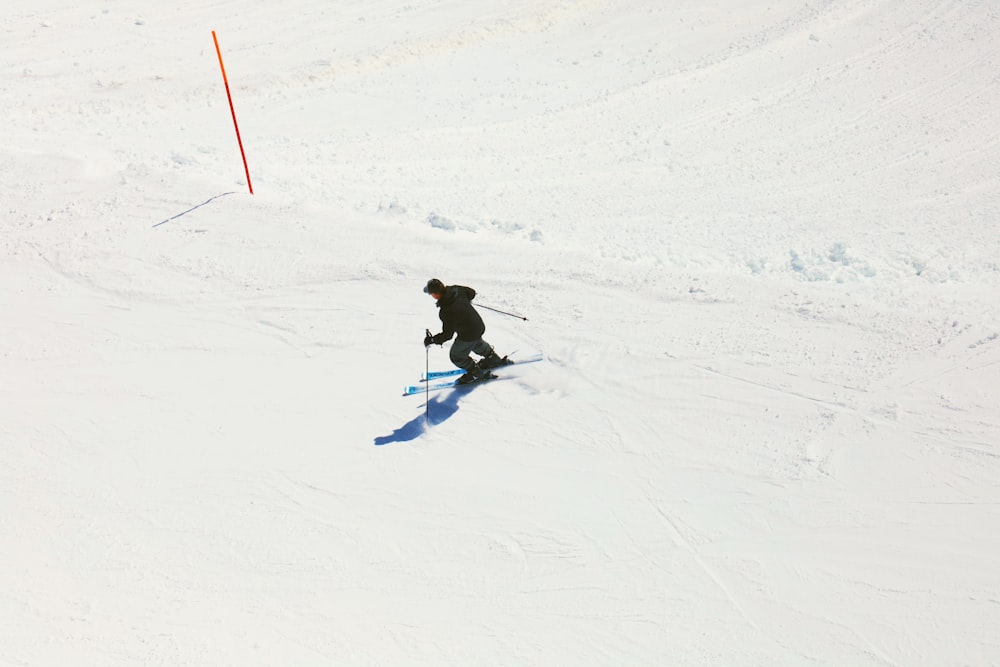 a man riding skis down a snow covered slope