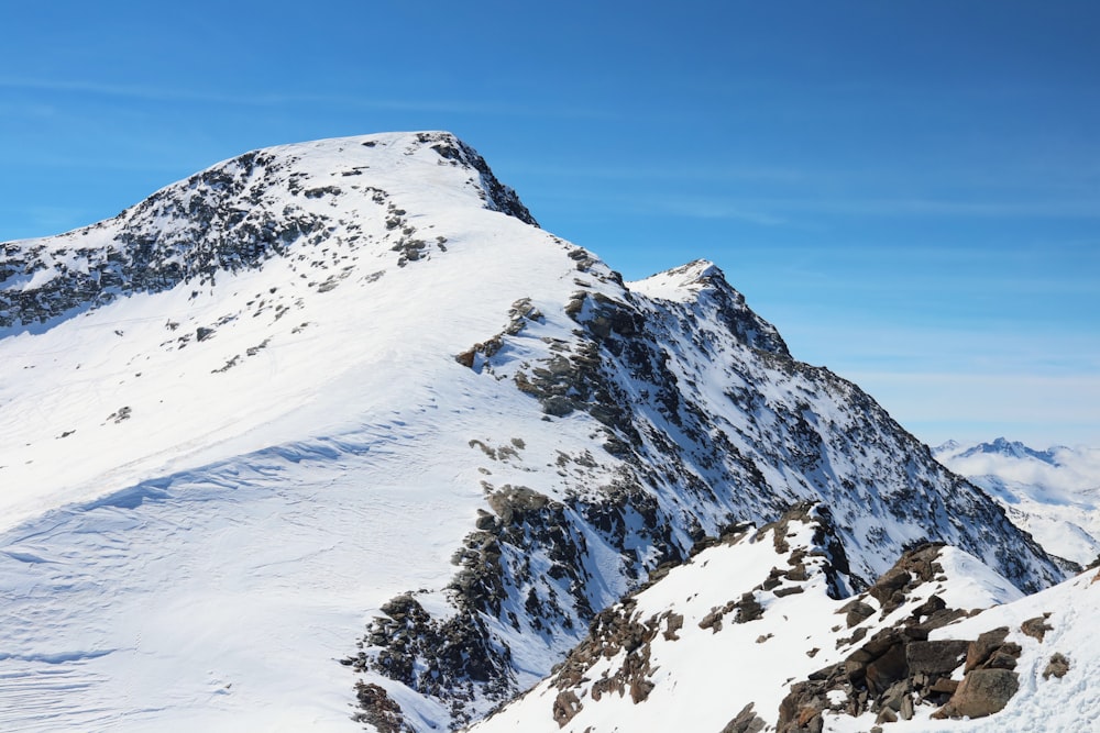 a mountain covered in snow with a sky background