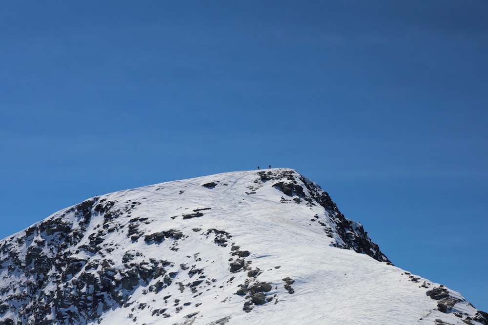 a snowboarder is going down the side of a snowy mountain