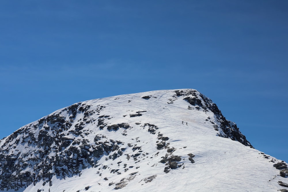 a snow covered mountain under a blue sky