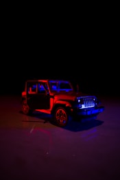 a red and blue jeep in the dark
