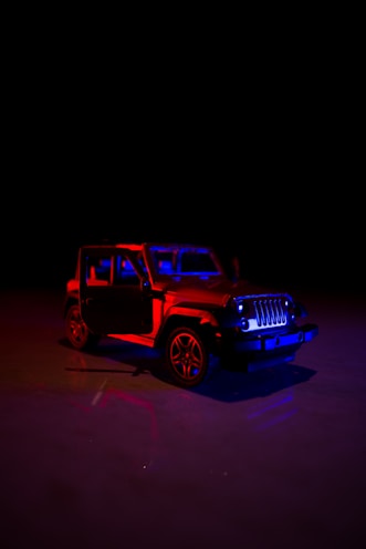 a red and blue jeep in the dark